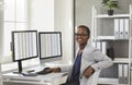 Happy African American accountant sitting at her office desk with desktop computers Royalty Free Stock Photo