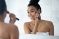 Happy African American beautiful girl putting makeup Royalty Free Stock Photo