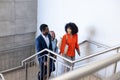 Happy african american business people walking and talking on stairs