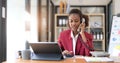 Happy african-american business woman talking on mobile at office. Young female manager consulting on phone, using Royalty Free Stock Photo