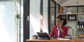 Happy african-american business woman talking on mobile at office. Young female manager consulting on phone, using Royalty Free Stock Photo