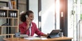 Happy african-american business woman talking on mobile at office. Young female manager consulting on phone, using Royalty Free Stock Photo