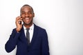 Happy african american businessman talking on mobile phone against white wall Royalty Free Stock Photo