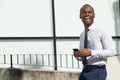 Happy african american businessman walking with phone in city Royalty Free Stock Photo