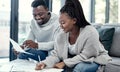 Happy African American couple doing finance planning, writing budget paperwork on sofa at home. Smiling boyfriend and Royalty Free Stock Photo