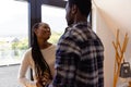 Happy african american couple embracing by window at home Royalty Free Stock Photo