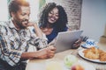 Happy african american couple are having breakfast together in the morning at the wooden table.Smiling black man and his Royalty Free Stock Photo