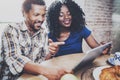 Happy african american couple are having breakfast together in the morning at the wooden table.Smiling black man and his Royalty Free Stock Photo