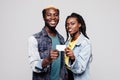 Happy african american couple holding small blank banner or credit card smiling at camera isolated on white background Royalty Free Stock Photo