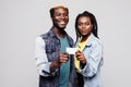 Happy african american couple holding small blank banner or credit card smiling at camera isolated on white background Royalty Free Stock Photo