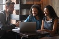 Happy biracial couple meeting with architect in coffeehouse Royalty Free Stock Photo