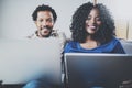 Happy african american couple relaxing together on the sofa.Young black man and girl using modern notebooks at home in Royalty Free Stock Photo