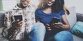 Happy african american couple relaxing together on the sofa.Young black man and his girlfriend using mobile phones while Royalty Free Stock Photo