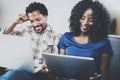 Happy african american couple relaxing together on the sofa.Young black man and his girlfriend using modern laptops at Royalty Free Stock Photo