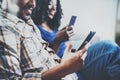 Happy african american couple relaxing together on the sofa.Young black man and his girlfriend using smartphones while Royalty Free Stock Photo