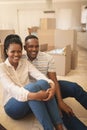 Happy African American couple sitting on floor and looking at camera Royalty Free Stock Photo