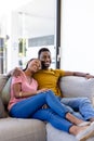 Happy african american couple smiling and embracing on couch at home Royalty Free Stock Photo
