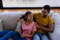 Happy african american couple smiling and embracing on couch at home Royalty Free Stock Photo