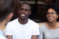 Happy African American couple talking with friend in cafe Royalty Free Stock Photo