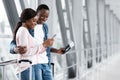 Happy African American Couple Using Smartphone In Airport Terminal, Booking Hotel Online Royalty Free Stock Photo