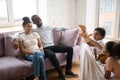 Happy african american couple watching cute siblings puppet show. Royalty Free Stock Photo