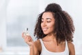 Happy african american curly girl using perfume Royalty Free Stock Photo