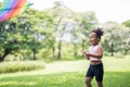 Happy African American cute little girl enjoys playing with kite in park on holidays in summer Royalty Free Stock Photo