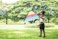 Happy African American cute little girl enjoys playing with kite in park on holidays in summer Royalty Free Stock Photo