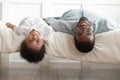 Smiling black dad and toddler son lying upside down Royalty Free Stock Photo