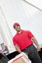 Happy African American delivery man pushing handtruck