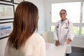 Happy African American doctor greeting female patient Royalty Free Stock Photo