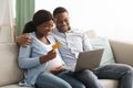 Happy african american expecting family using laptop, shopping online Royalty Free Stock Photo