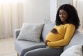 Happy african expecting lady spending time at home, copy space
