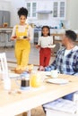 Happy african american family bringing fresh fruits on table in dining room at home, copy space