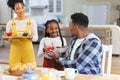Happy african american family bringing fresh fruits on table in dining room at home, copy space