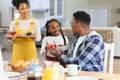 Happy african american family bringing fresh fruits on table in dining room at home, copy space