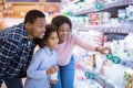 Happy African American family buying milk products at modern supermarket, empty space Royalty Free Stock Photo