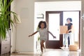 Happy African American family with cardboard boxes in new home