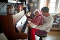 Happy African American Family on Christmas morning play on piano