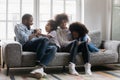 Happy african american couple playing with cute children on sofa. Royalty Free Stock Photo