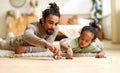 Happy african american family father and child son laughing while playing toys together at home Royalty Free Stock Photo