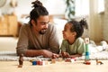 Happy african american family father and child son laughing while playing toys together at home Royalty Free Stock Photo