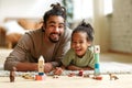 Happy african american family father and child son laughing while playing toys together at home Royalty Free Stock Photo