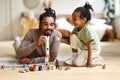 Happy african american family father and child son laughing while playing toys together at home Royalty Free Stock Photo