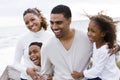 Happy African-American family of four on beach