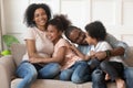 Happy african american family of four laughing bonding on sofa Royalty Free Stock Photo