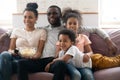 Happy african american family with kids watching funny tv show. Royalty Free Stock Photo