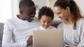 Happy African American family with little son using laptop together Royalty Free Stock Photo