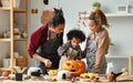 Happy african american family mother, father and child son carving pumpkin for Halloween holiday together at home Royalty Free Stock Photo