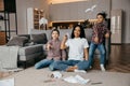 Happy African american family, mother and two sons having fun time at home and fly paper airplanes